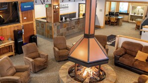 A lobby area with a stone fireplace, multiple sofas, and a reception desk. - Legacy Vacation Resorts - Steamboat Hilltop (Steamboat Springs)