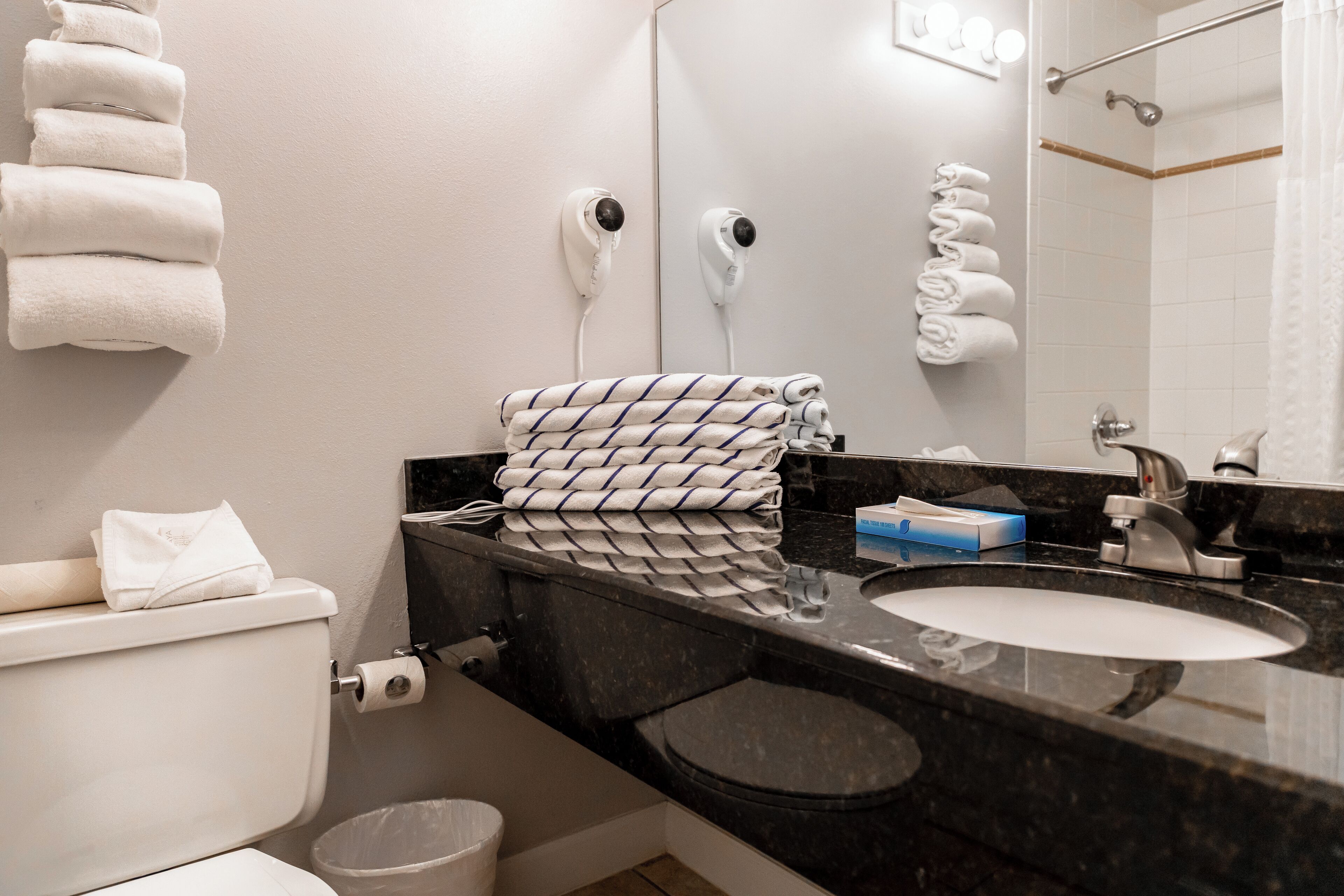 Une salle de bain équipée de toilettes, d’un lavabo et d’un porte-serviettes.