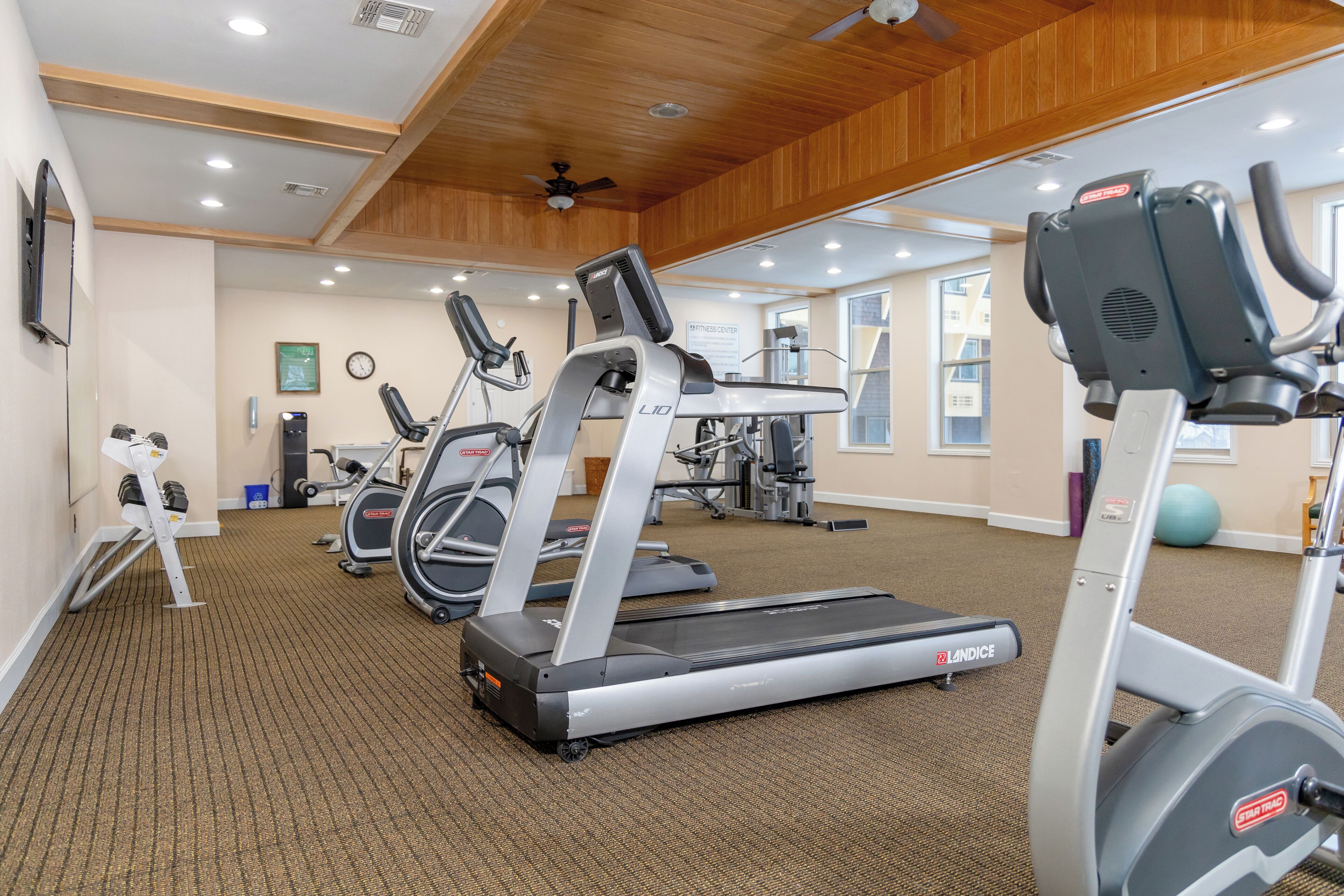 A gym with treadmills, ellipticals, and weight machines.
