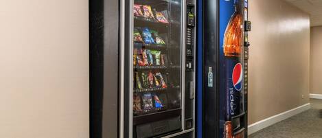 A vending machine with snacks and a Pepsi dispenser in a hallway.