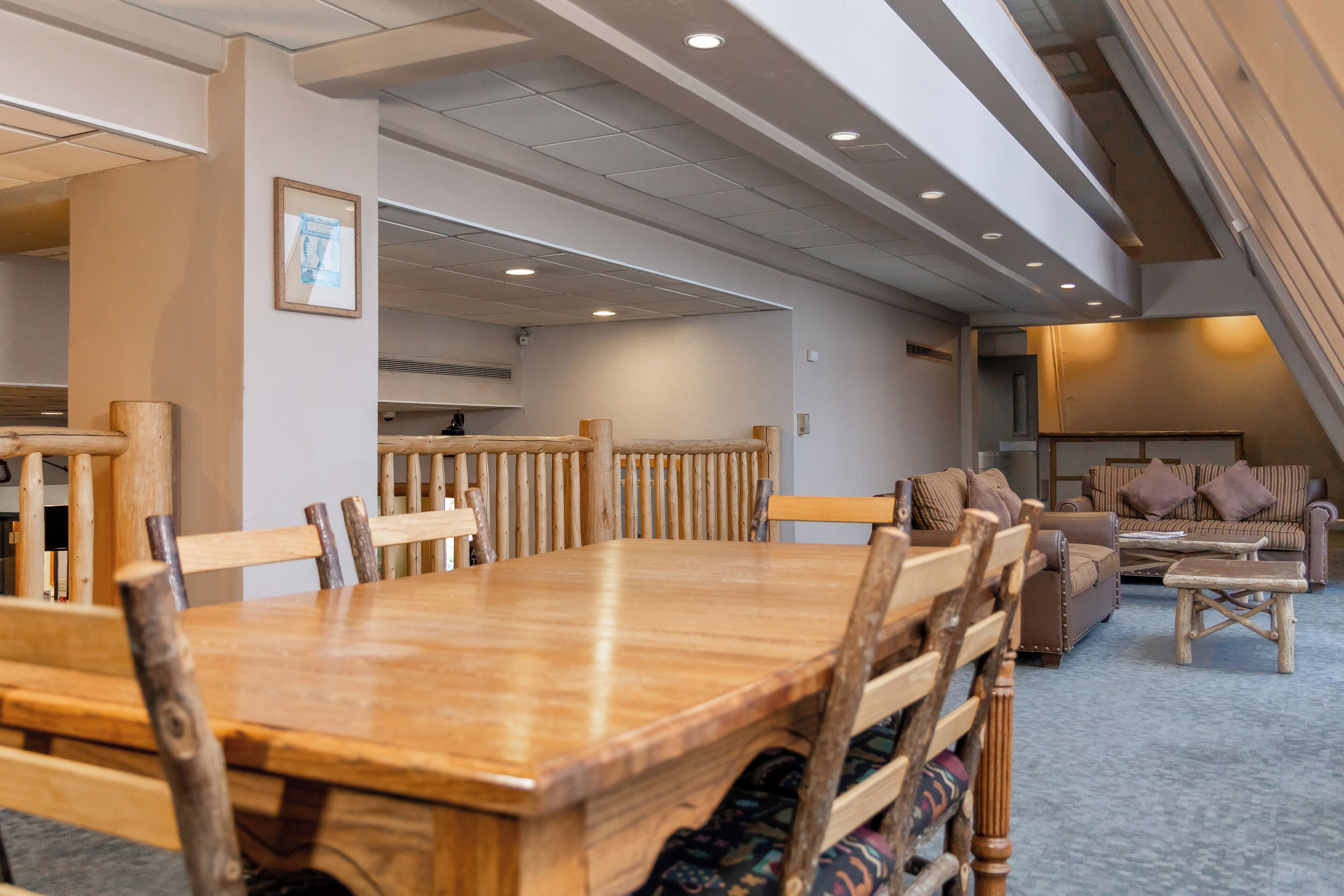 A spacious dining area with a long wooden table and chairs, a sofa, and a small coffee table.