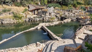 A natural hot spring area with wooden benches and a small wooden structure. - Legacy Vacation Resorts - Steamboat Hilltop (Steamboat Springs)