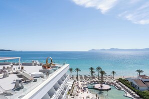 A rooftop terrace with outdoor seating and a pool area, overlooking a beach and the sea. - Hotel Condesa Mallorca (Alcúdia)