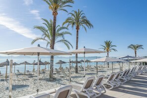 En la playa, arena blanca, toallas de playa, vóleibol de playa