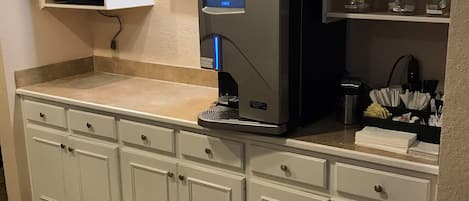Eine Küche mit integrierter Kaffeemaschine, Mikrowelle und Kühlschrank.