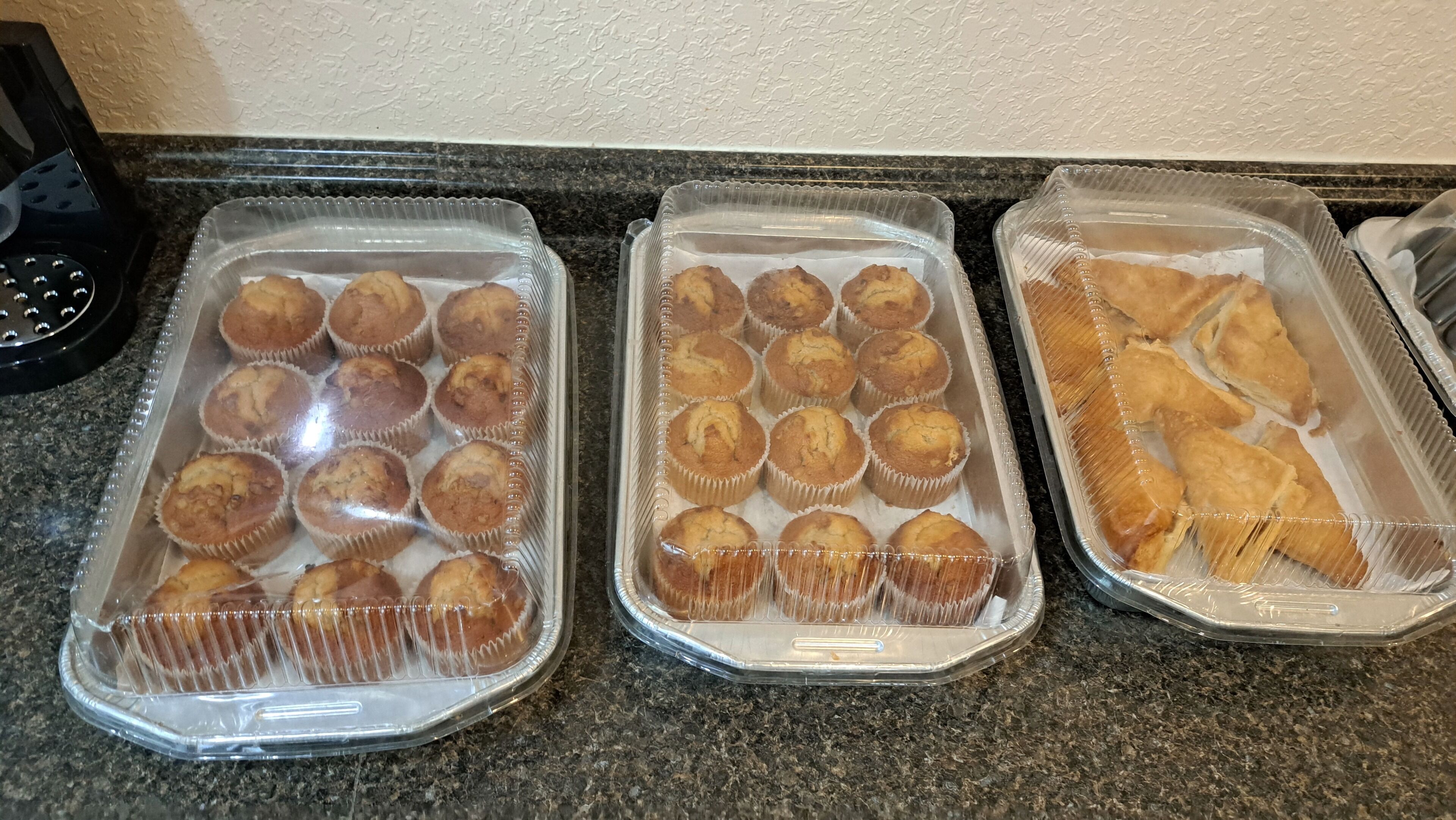 Three trays of baked goods on a countertop.