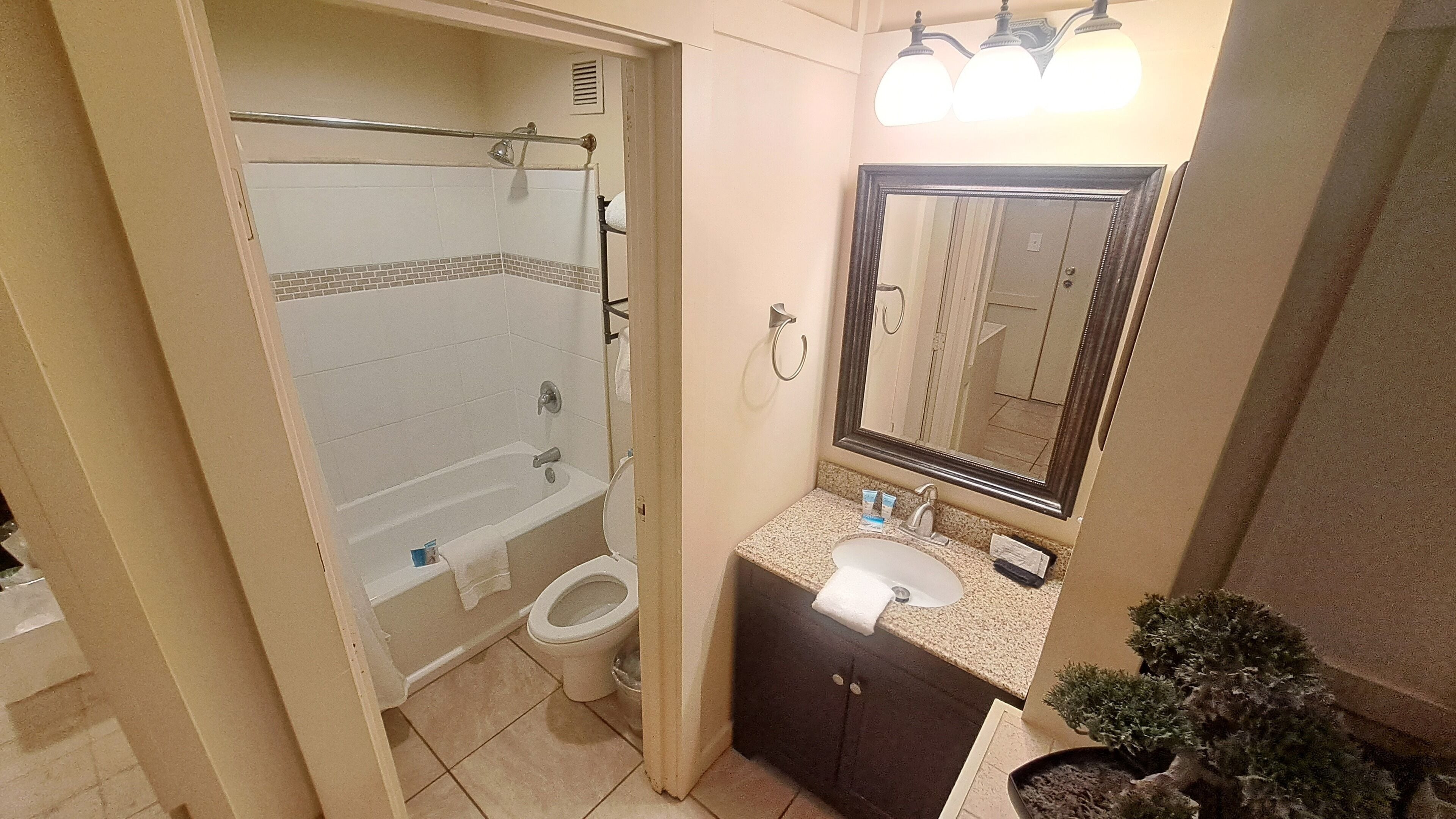 A bathroom with a bathtub, toilet, sink, and a mirror.