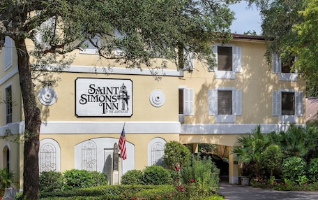 A building with a sign reading "Saint Simons Inn by the Lighthouse".