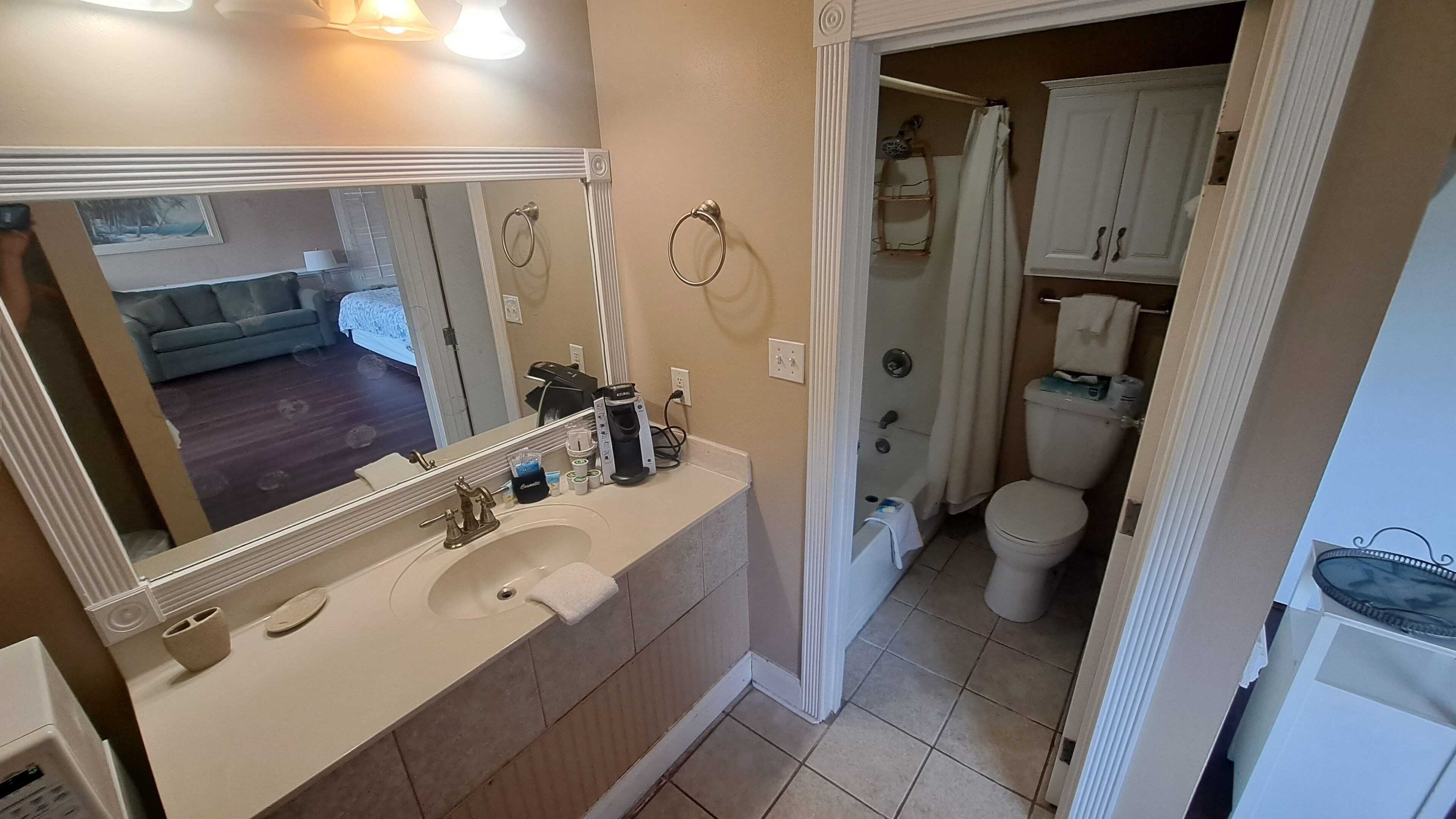 A bathroom with a sink, mirror, and toilet.