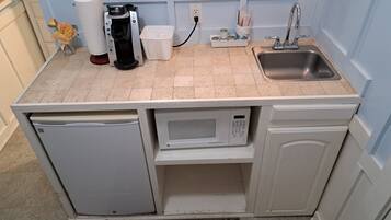 Una cocina compacta con lavavajillas integrado, microondas y cafetera.