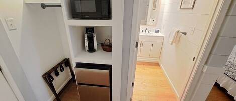 A compact kitchen with a microwave, coffee maker, and a small refrigerator.