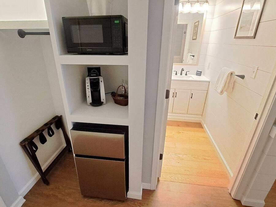 A compact kitchen with a microwave, coffee maker, and a small refrigerator.