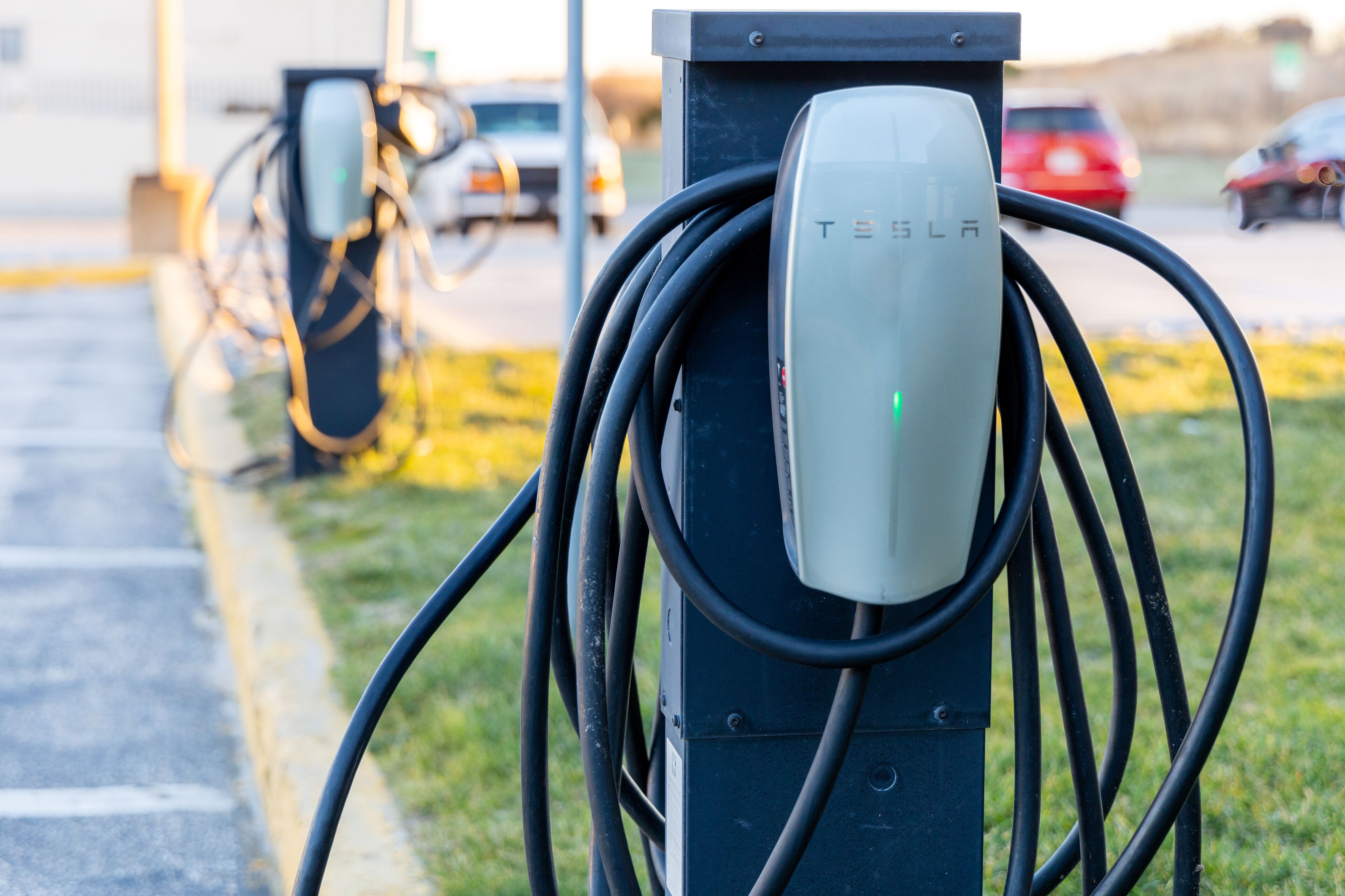 Eine Tesla Ladestation mit angeschlossenem Ladekabel an einem Fahrzeug.