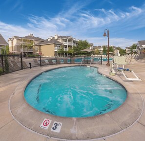 A swimming pool with a 3 ft depth limit sign, surrounded by a fence, and adjacent to a building with a balcony. - WorldMark Windsor (Windsor)