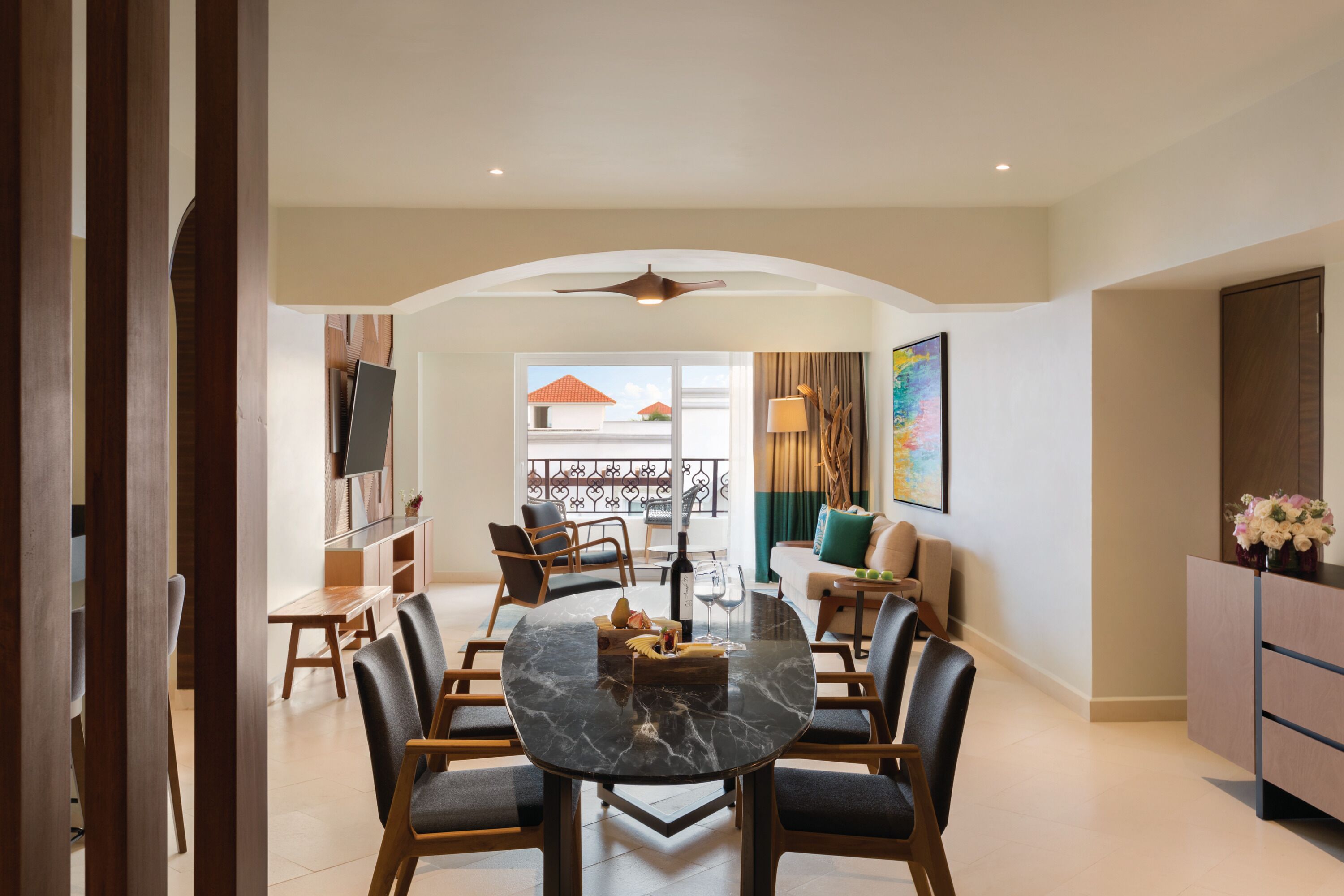 Un espace repas moderne avec une table ronde, des chaises et un téléviseur.