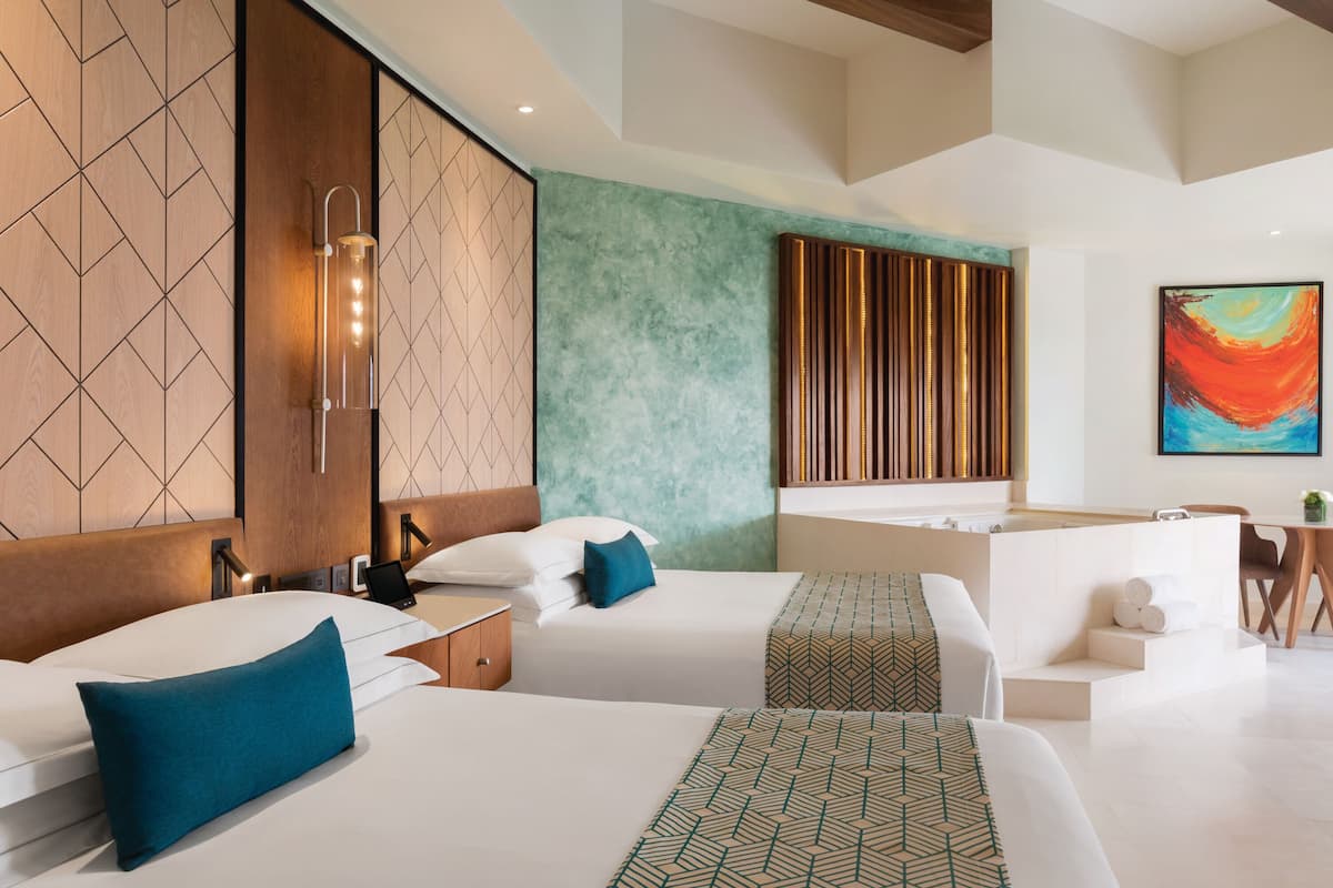 Una habitación de hotel moderna con dos camas, un área de estar y una bañera.