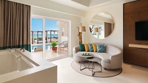 A modern hotel room with a large bathtub, a sofa with colorful cushions, a round coffee table, and a TV mounted on the wall. - Hyatt Vivid Playa Del Carmen - Adults Only - All Inclusive                                                                    (Playa del Carmen)