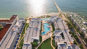 An aerial view of a resort with multiple buildings, a central swimming pool, and a beach area. - Hyatt Vivid Playa Del Carmen - Adults Only - All Inclusive                                                                    (Playa del Carmen)