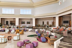 A spacious lobby with multiple seating areas, a staircase, and artwork on the walls. - Hyatt Vivid Playa Del Carmen - Adults Only - All Inclusive                                                                    (Playa del Carmen)