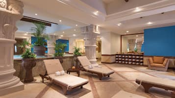 A spacious lobby with lounge chairs, a reception area, and decorative columns.
