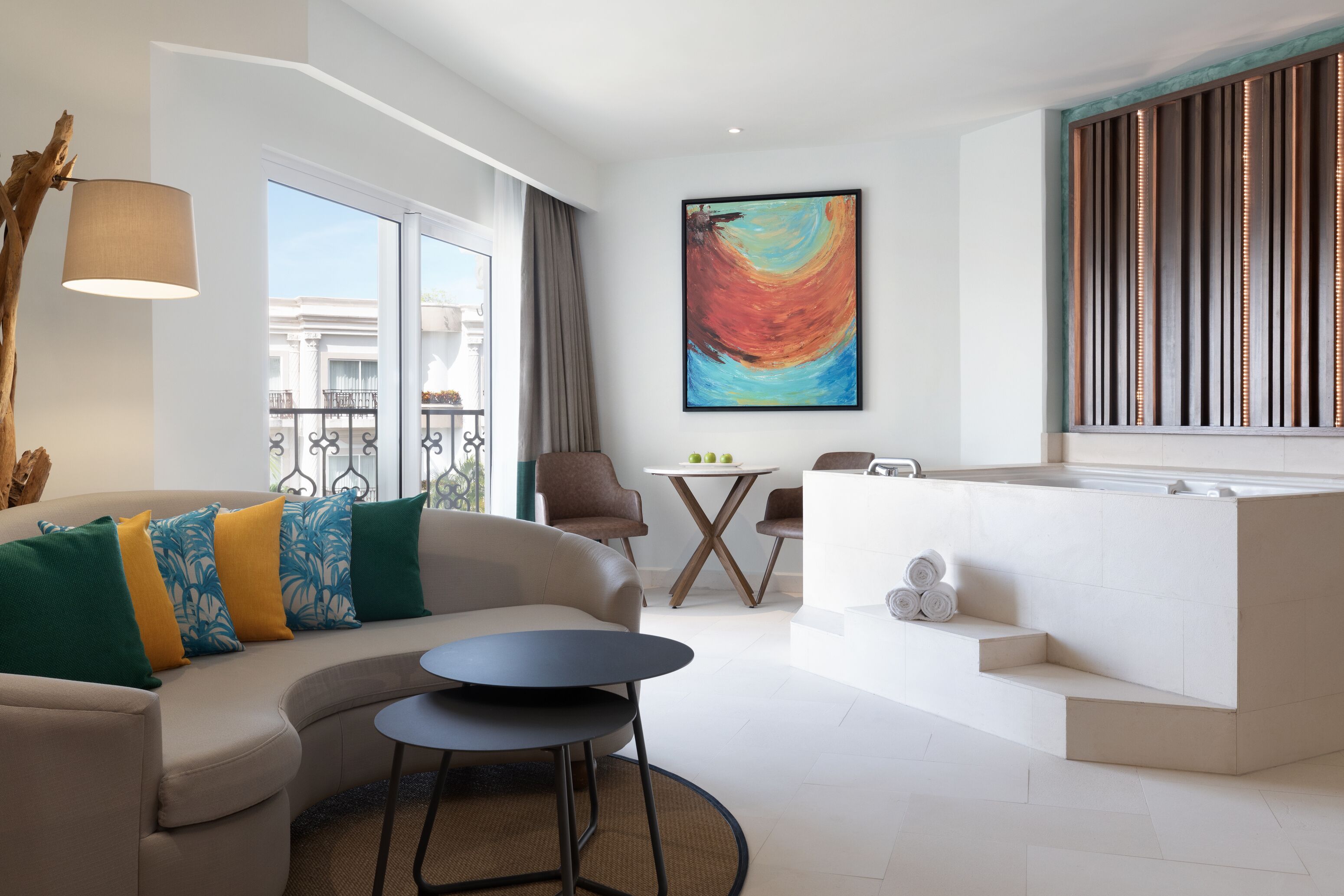 Un salon moderne avec un canapé, une table basse et un tableau accroché au mur.
