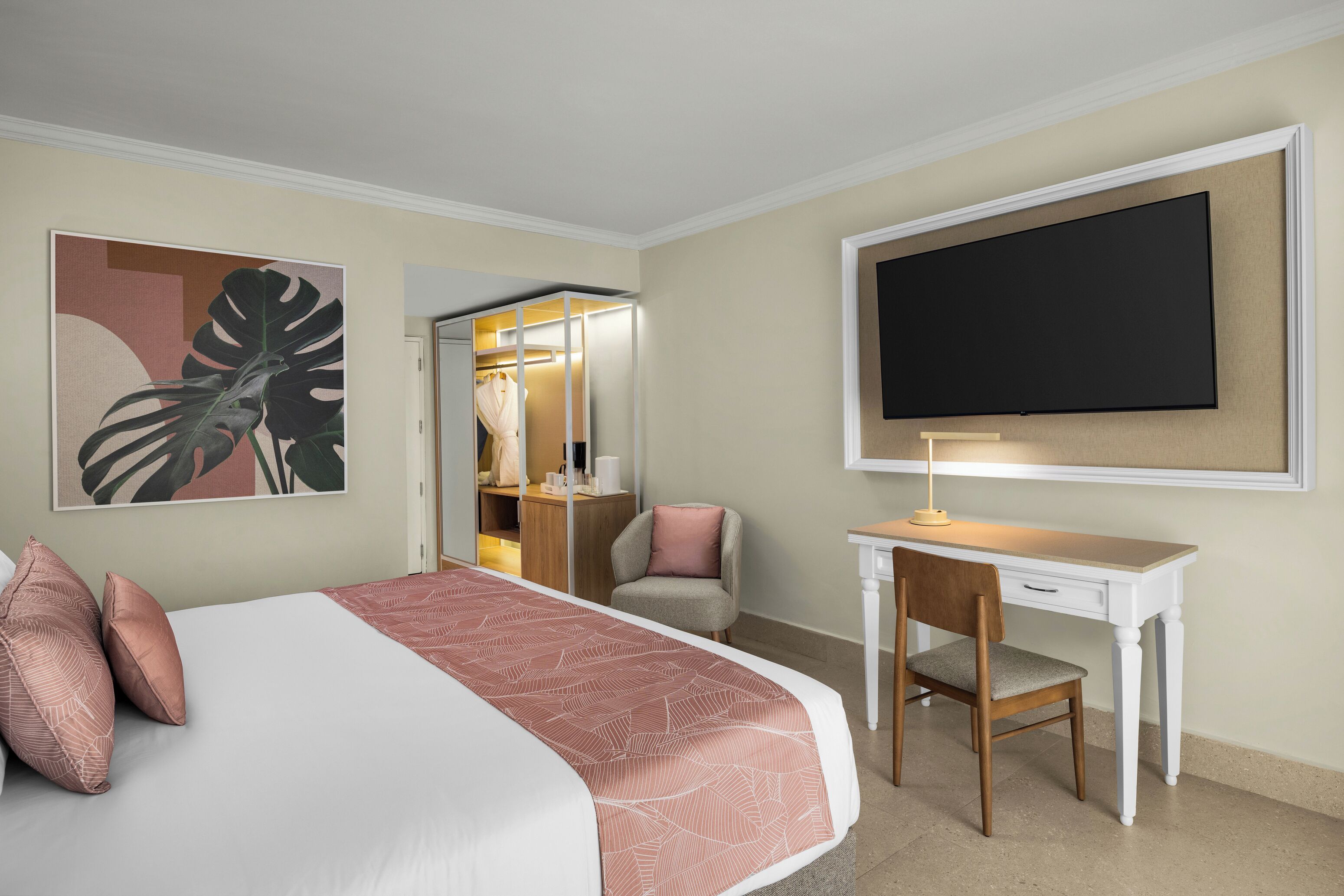 A hotel room with a bed, a desk, a chair, a television, and a mirror.