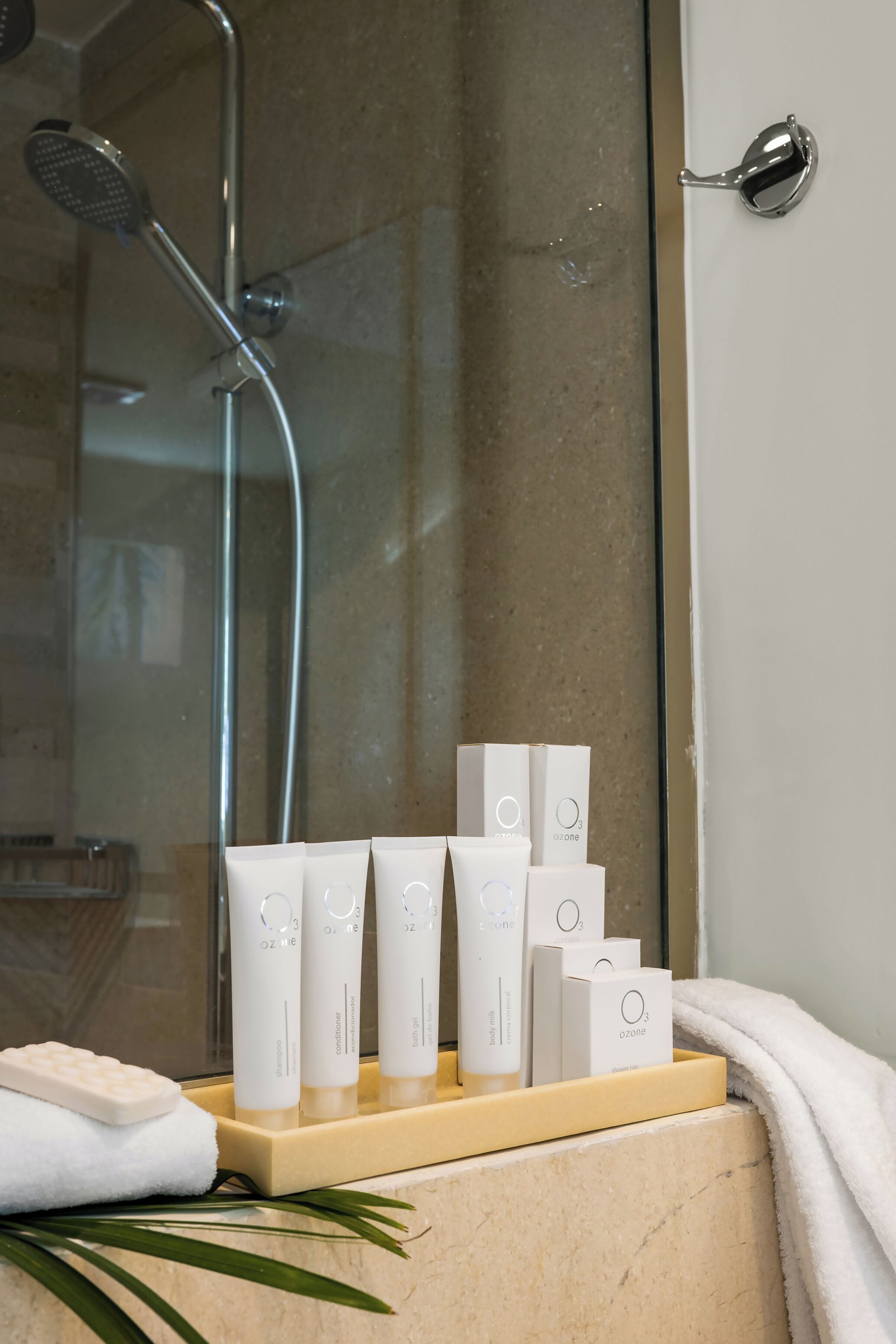 A bathroom with a shower, a sink, and a shelf with toiletry items.