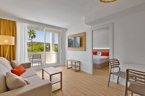Una habitación de hotel moderna con balcón, cama, escritorio y sofá.