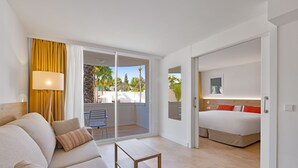 A modern hotel room with a balcony, a bed, a sofa, and a small table. - Palmanova Beach Apartments by TRH (Calvia)