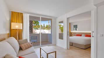 Una habitación de hotel moderna con balcón, cama, sofá y una pequeña mesa.