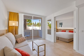A modern hotel room with a balcony, a sofa, a bed, and a small table. - Palmanova Beach Apartments by TRH (Calvia)