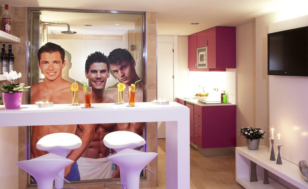 Un baño moderno con un espejo grande, un tocador con lavabo y una zona de bar con taburetes.