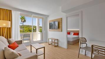 Una habitación de hotel moderna con balcón, cama, escritorio y sofá.