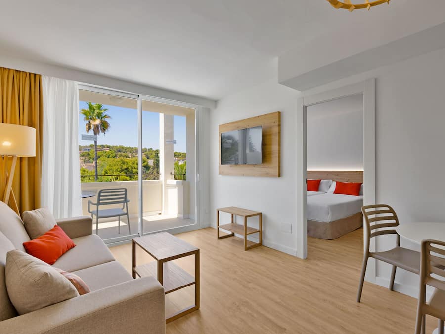 Une chambre d’hôtel moderne dotée d’un balcon, d’un lit, d’un bureau et d’un canapé.