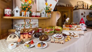 A table with various food items and decorations, including a banner with the word "nostalgia" and a heart-shaped decoration. - Hotel Bellavista (Giustino)