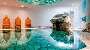 A modern indoor pool with a clear, reflective surface and a unique ceiling design featuring star-like lights. - Hotel Gianna (Tre Ville)