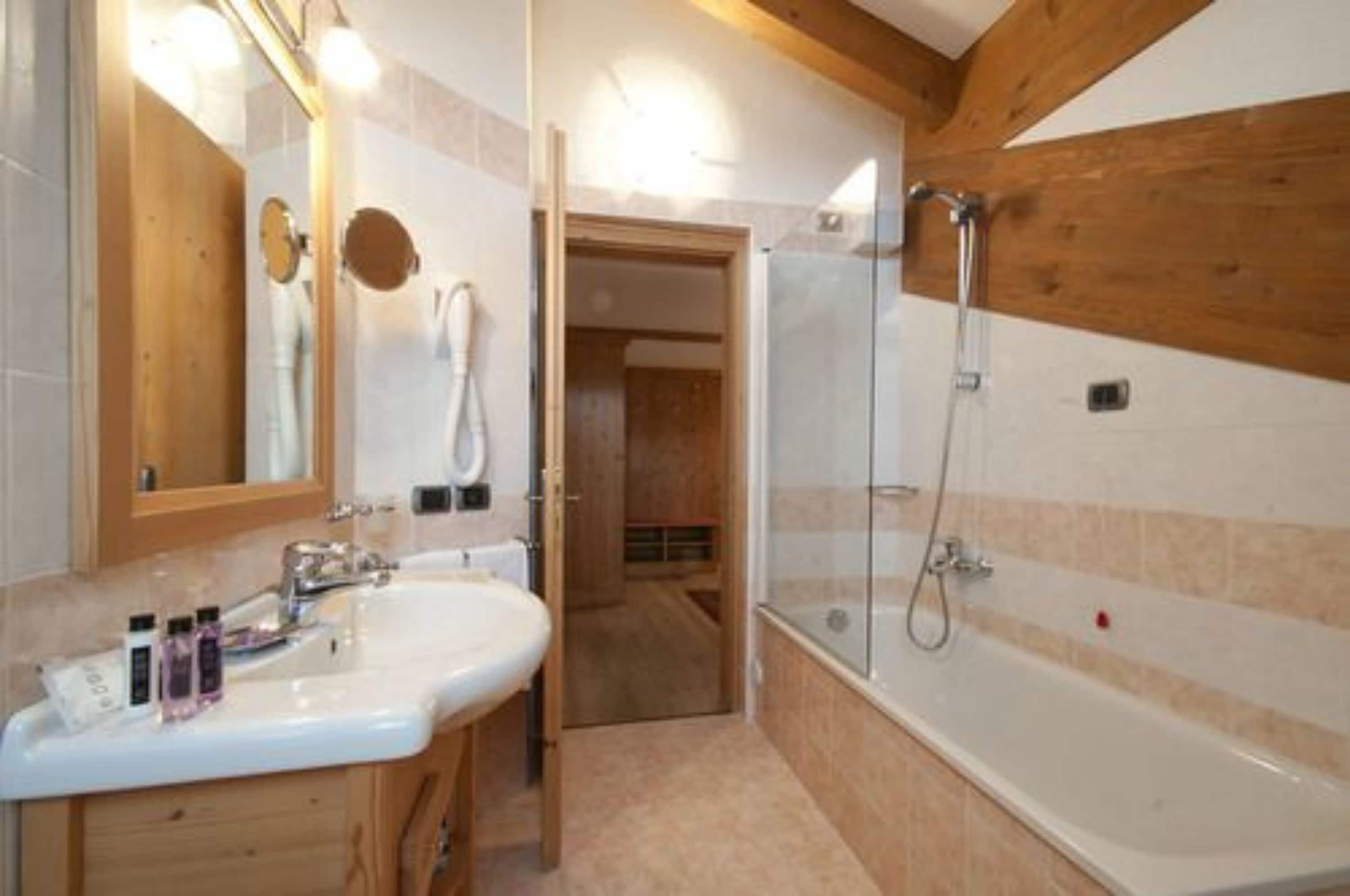 junior suite | bathroom | combined shower/bathtub, designer toiletries, hair dryer, bathrobes