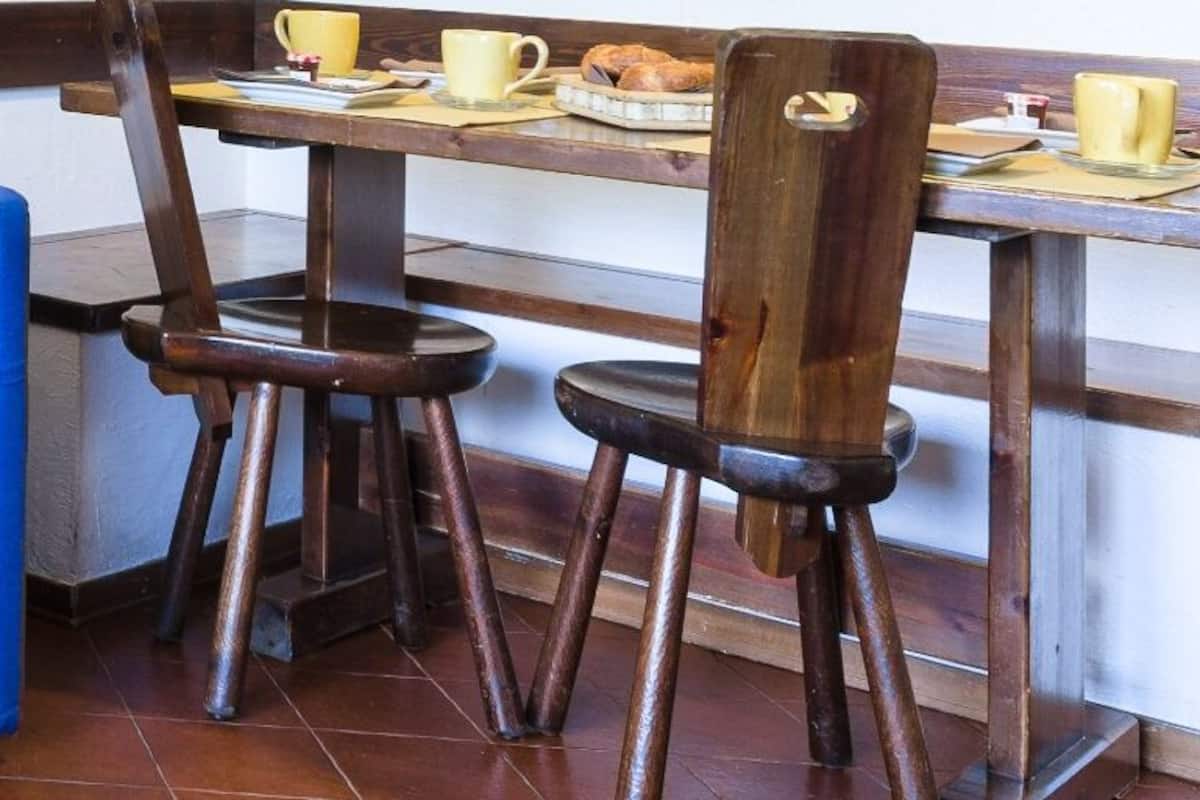 A room with a plaid sofa, a blue chair, and a wooden table with breakfast items.