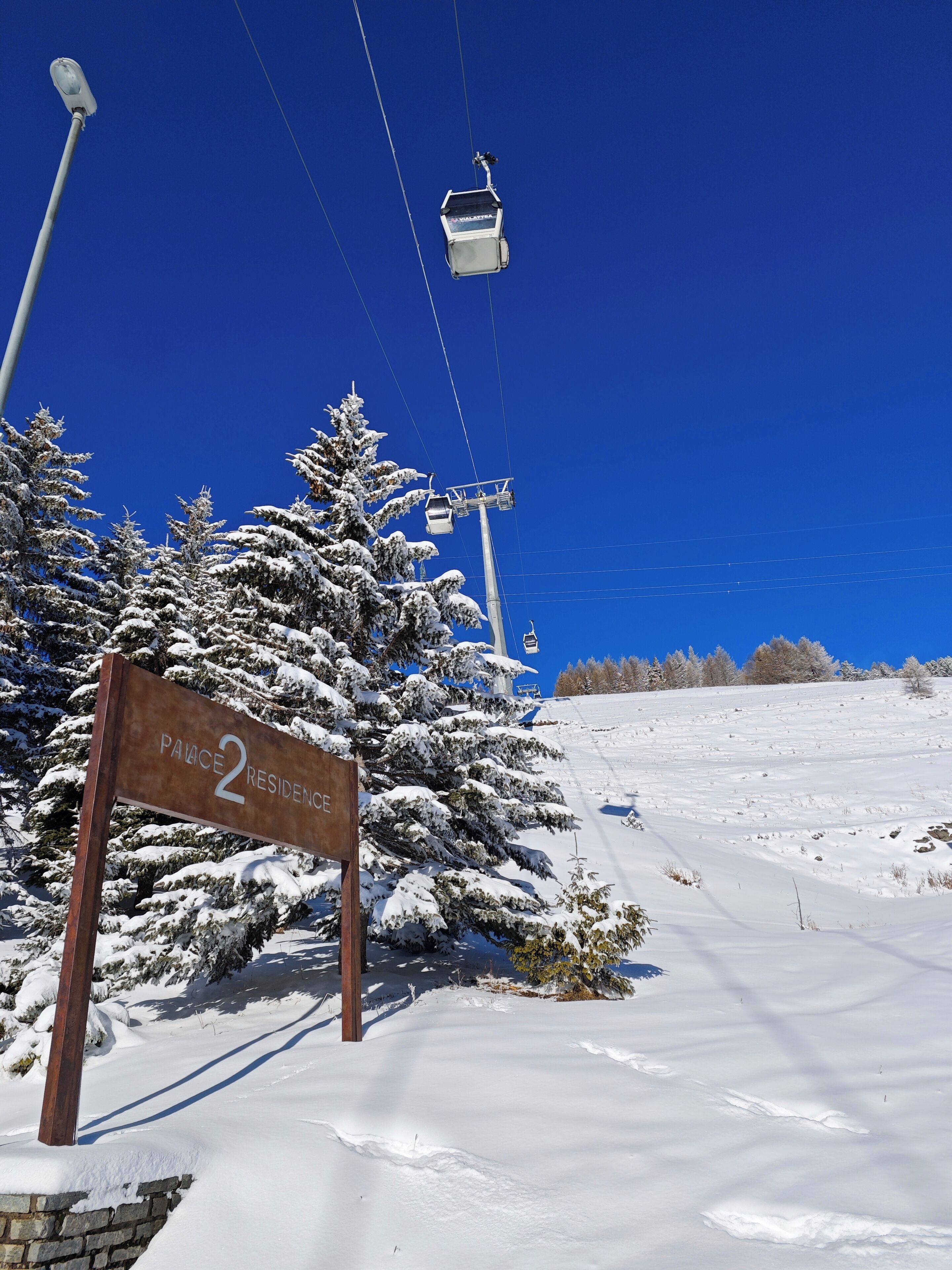 A snow-covered landscape with a sign reading "Palace 2 Residence".