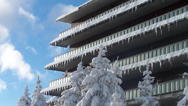 A multi-story building with balconies covered in snow, surrounded by snow-covered trees. - Resort Palace Sestriere 1 E 2 (Sestriere)