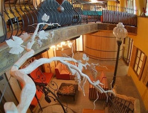 A multi-level interior with a central staircase, seating areas, and a decorative metal railing.