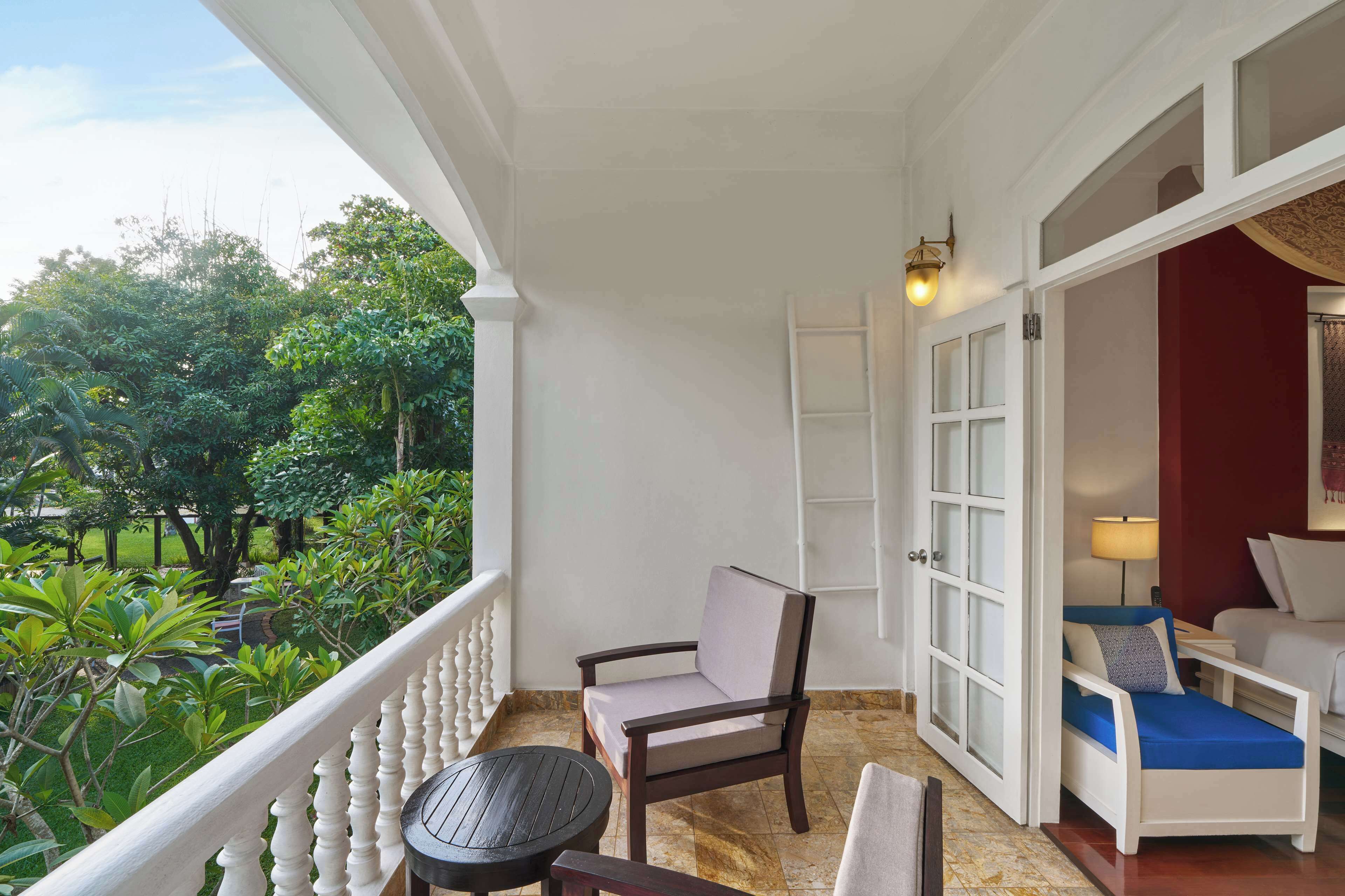 A balcony with a chair, a small table, and a sofa.