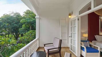 A balcony with a chair, a small table, and a sofa.