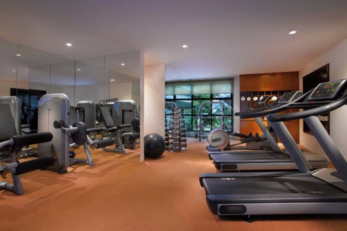 A gym with treadmills, weight machines, and exercise balls.