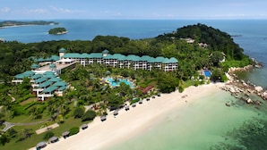 An aerial view of a resort with multiple buildings, a beach, and a pool area. - Homm Laguna Bintan (Bintan)