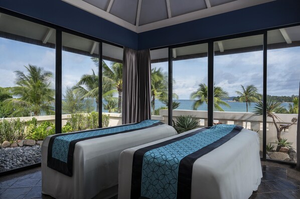 A room with two beds, large windows, and a view of the ocean and palm trees. - Homm Laguna Bintan (Bintan)