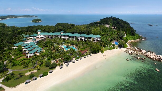 An aerial view of a resort with a beach, a pool, and a forested area. - Homm Laguna Bintan (Bintan)