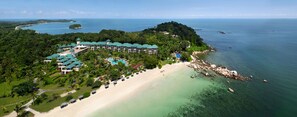 An aerial view of a resort with a beach, a pool, and a forested area. - Homm Laguna Bintan (Bintan)