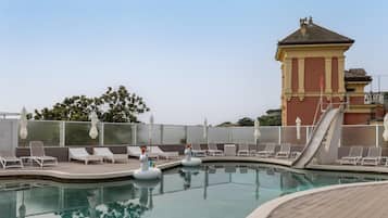 Una piscina al aire libre de temporada, sombrillas