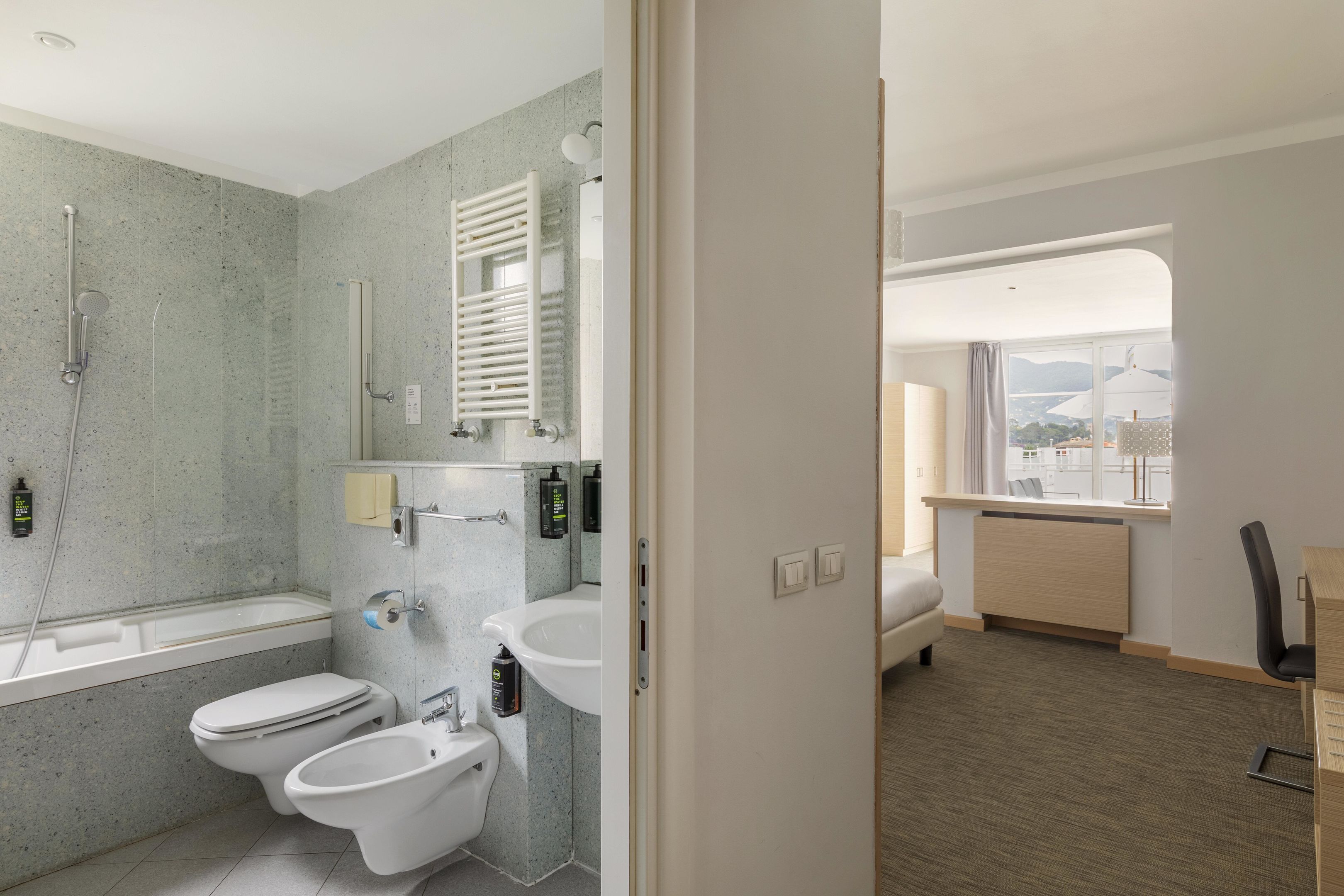 Une salle de bain moderne équipée d’une baignoire, de deux toilettes, d’un bidet et d’un lavabo.